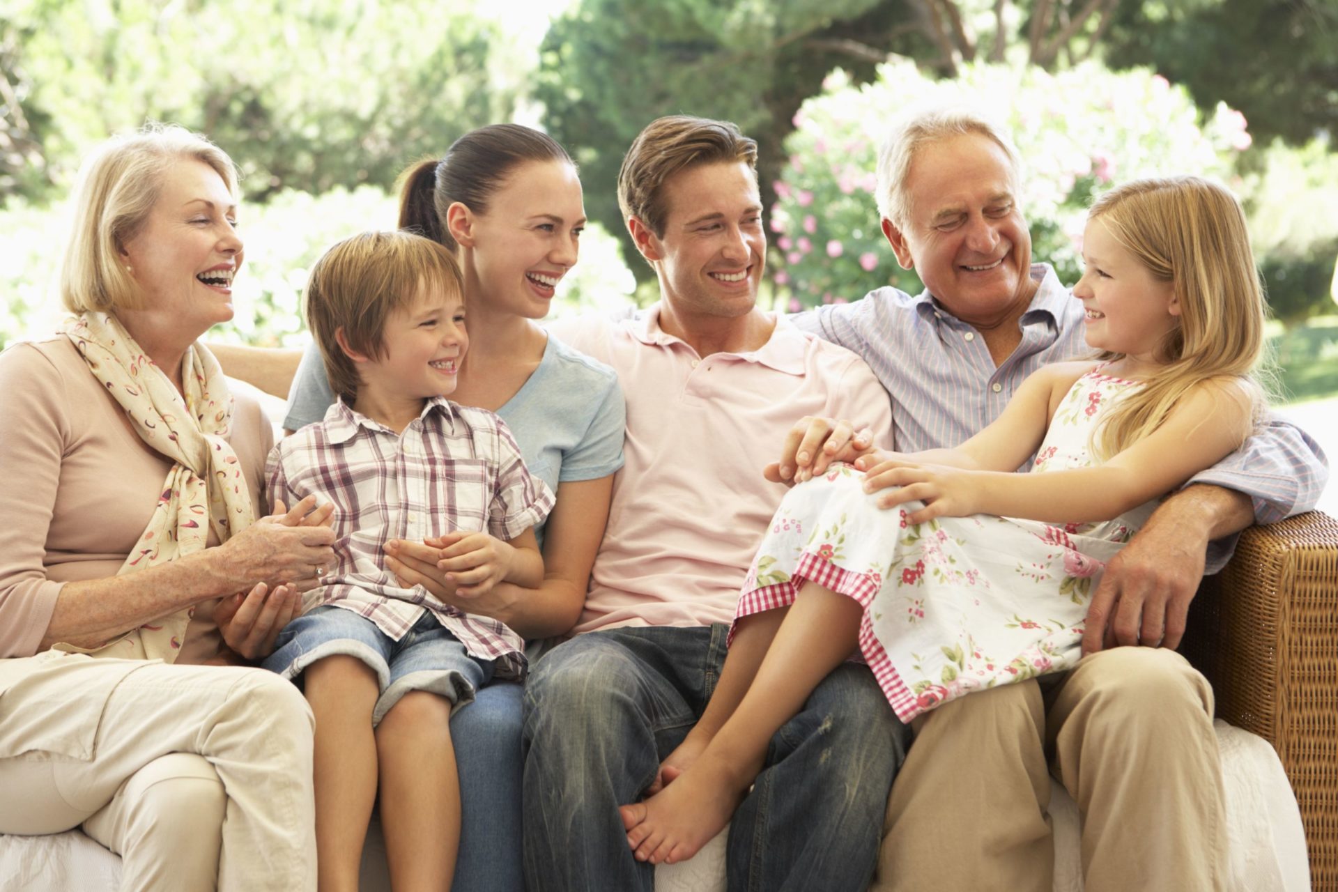 A smiling family of three generations sitting together. The family members are happy and relaxed.