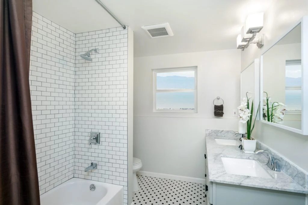 Bathroom interior with white tile shower and double sink