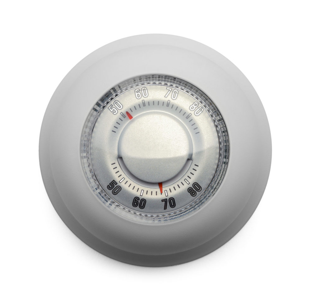 A round thermostat dial with temperature markings