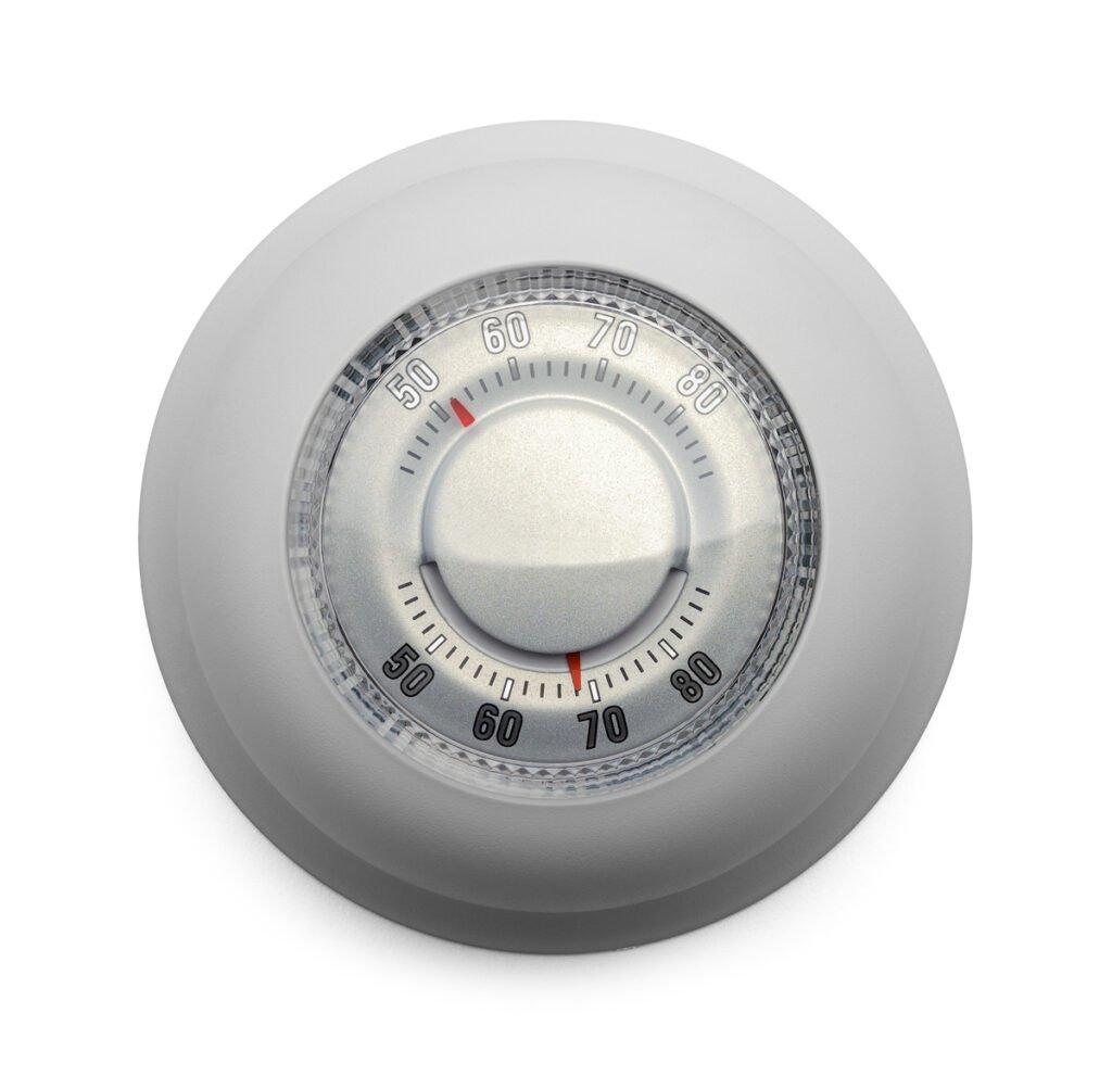 A round thermostat dial with temperature markings