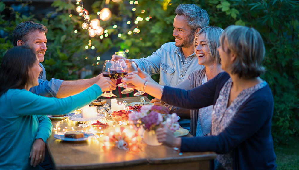 Group of friends clinking wine glasses at a dinner table. A warm and joyful moment with friends.