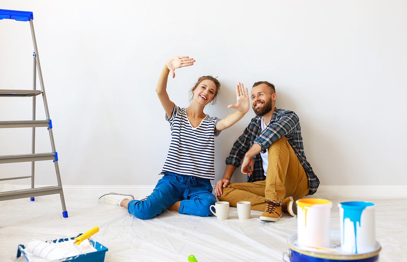 Happy couple painting wall. Home renovation project.