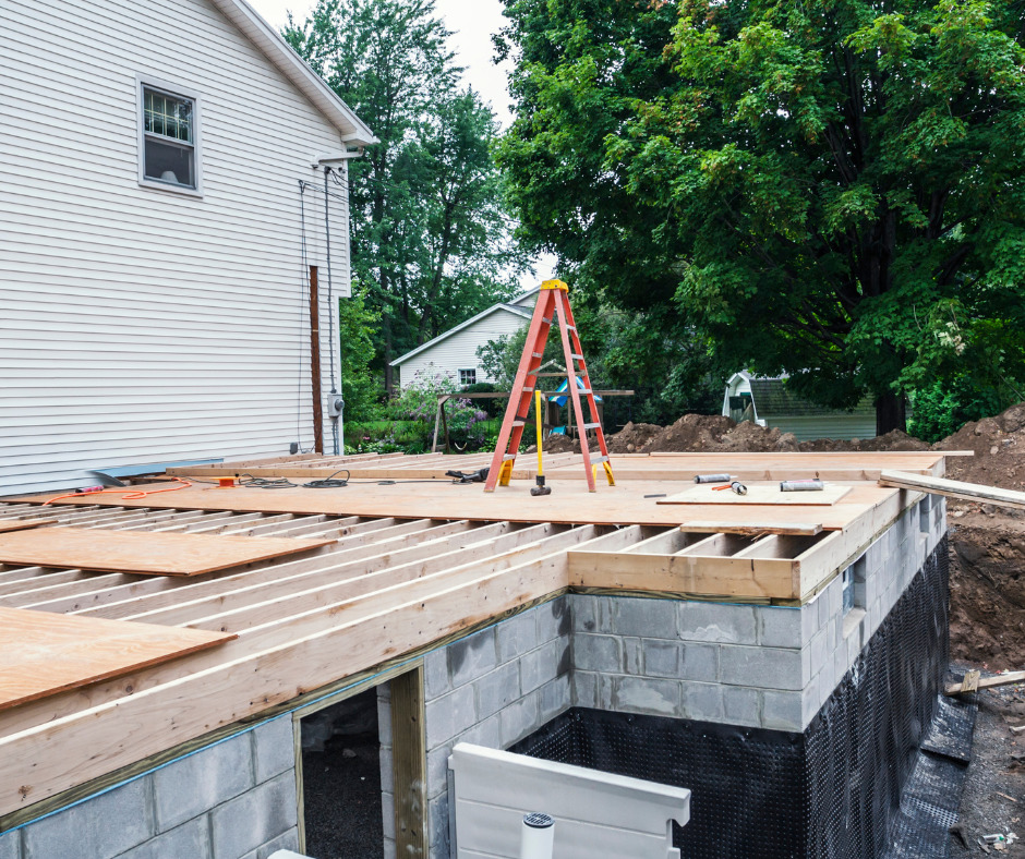 A new home construction site with a foundation and scaffolding. The building's base is made of concrete blocks.
