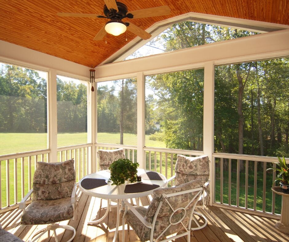 Cozy screened-in porch with outdoor furniture. Natural light.