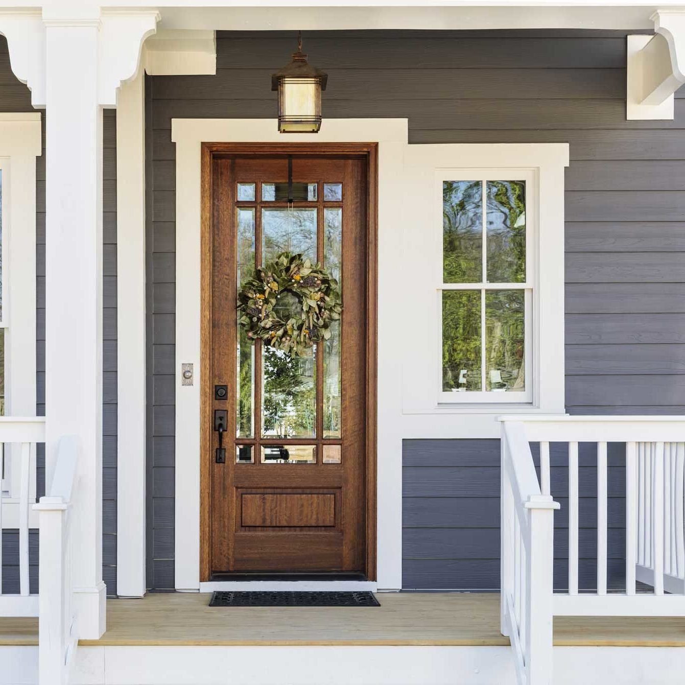 Beautiful wooden front door with wreath on porch A wooden front door with a wreath on a porch