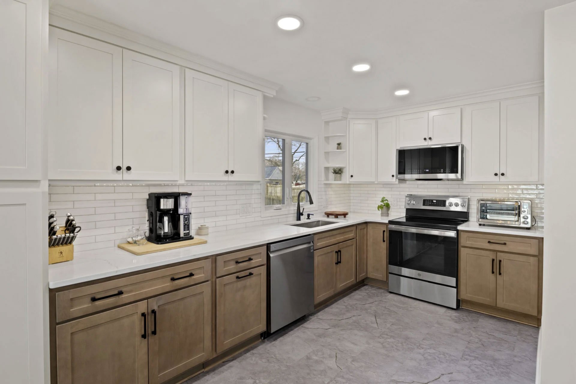 A modern kitchen with white cabinets and wood drawers
