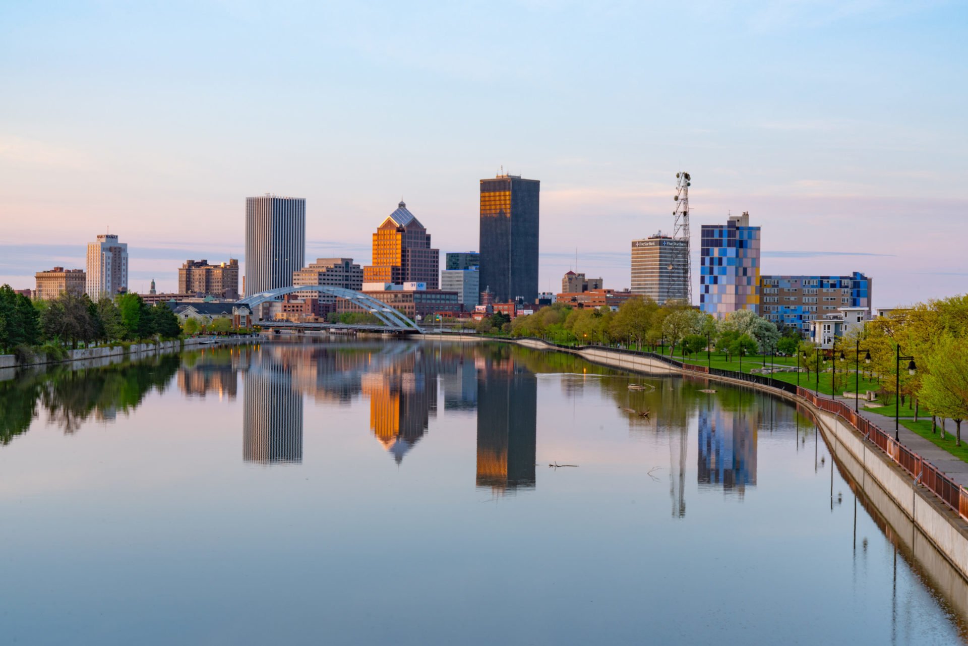 City skyline reflected in river. Calm water surface.