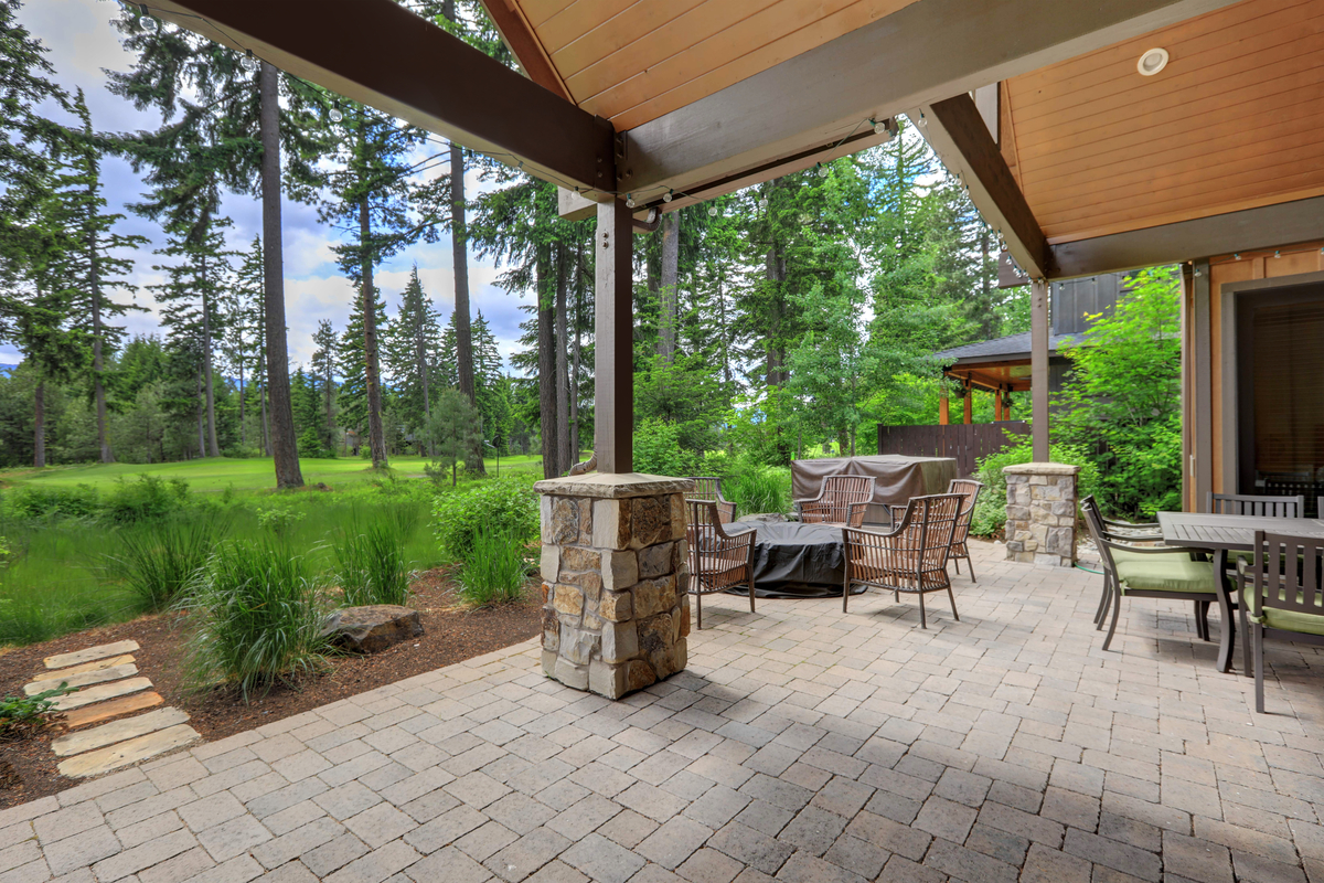 Outdoor patio with seating and table. Forest landscape in background.