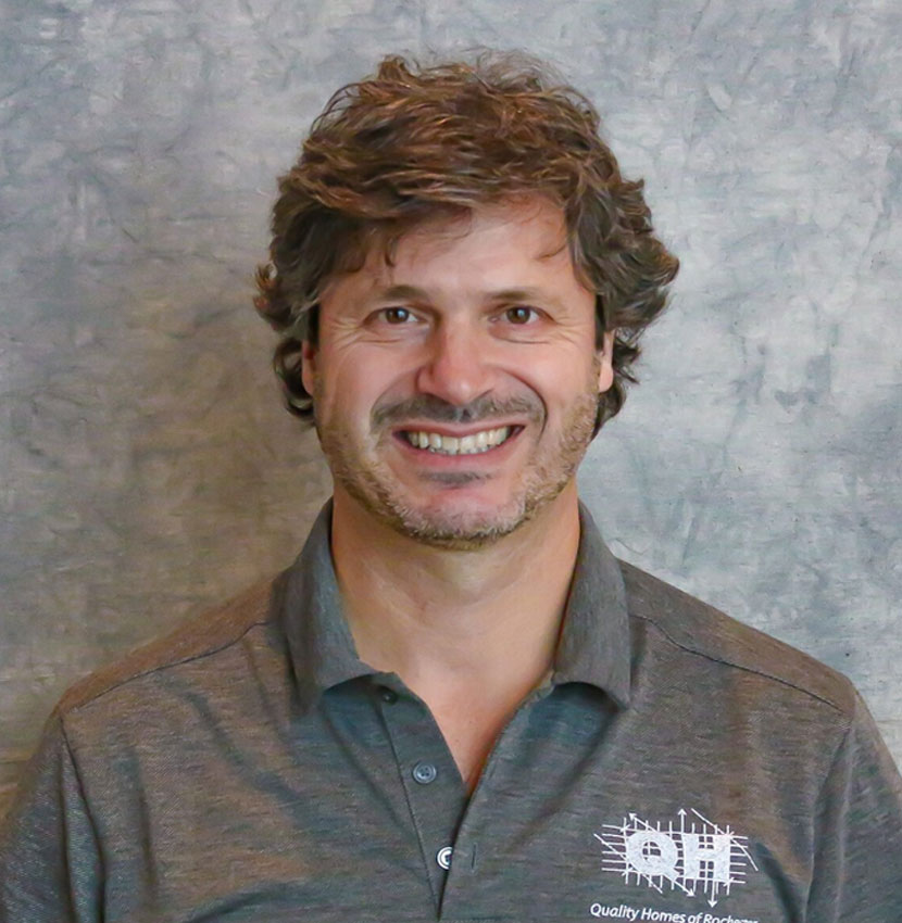 Man with brown hair and a short beard smiling