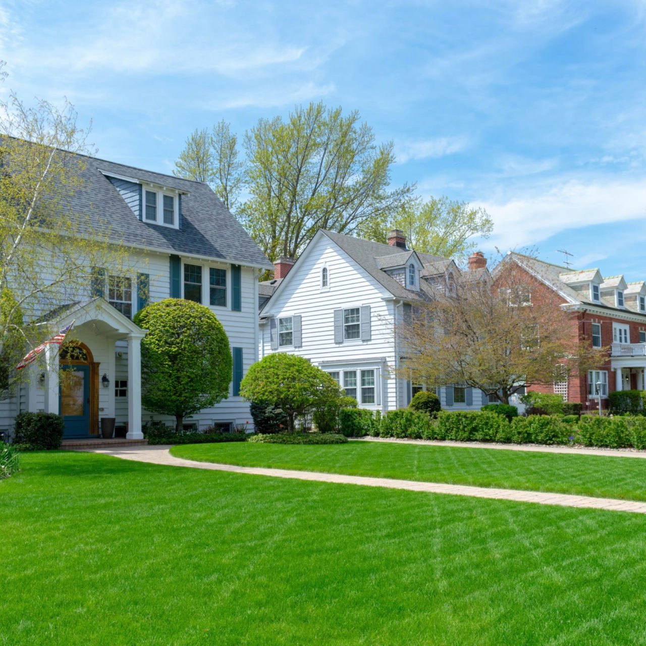 Beautiful homes with well-manicured lawn. A serene neighborhood scene.