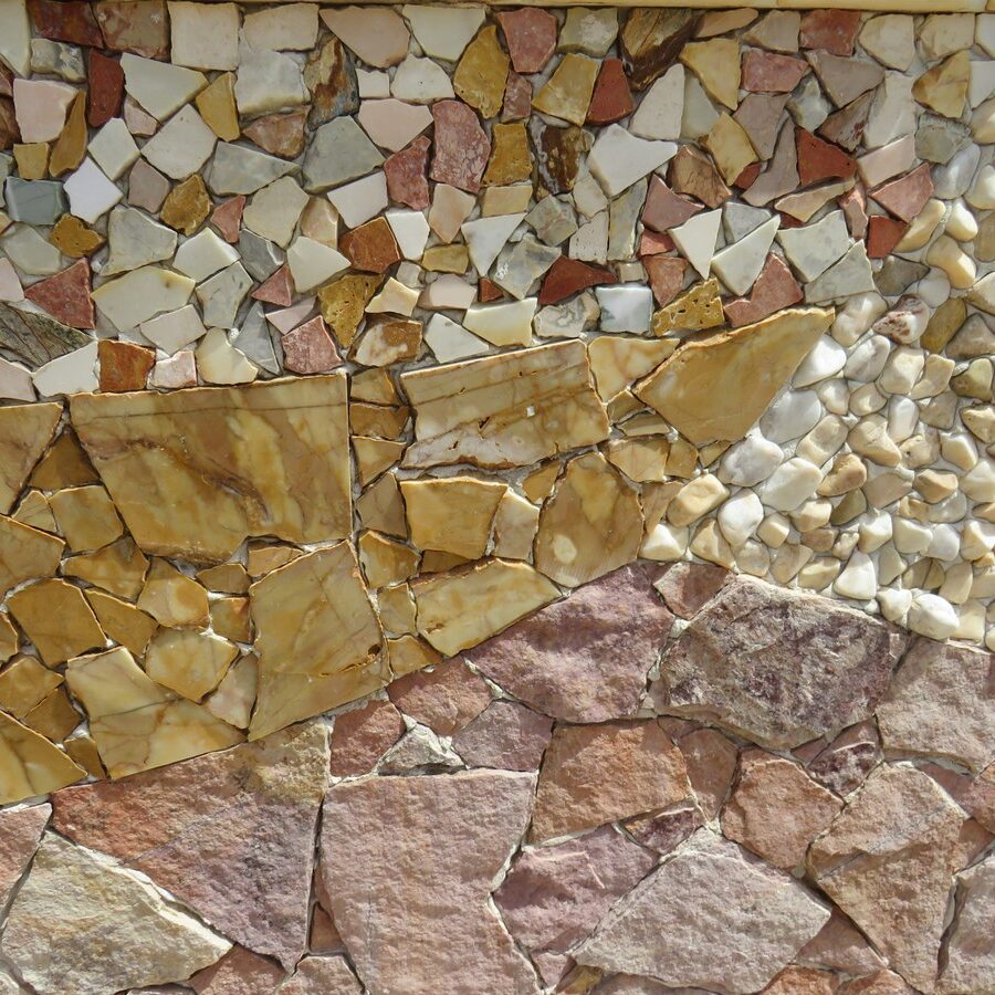 A mosaic art piece created with small stones and pebbles in various colors. The image showcases a decorative arrangement of tiles.