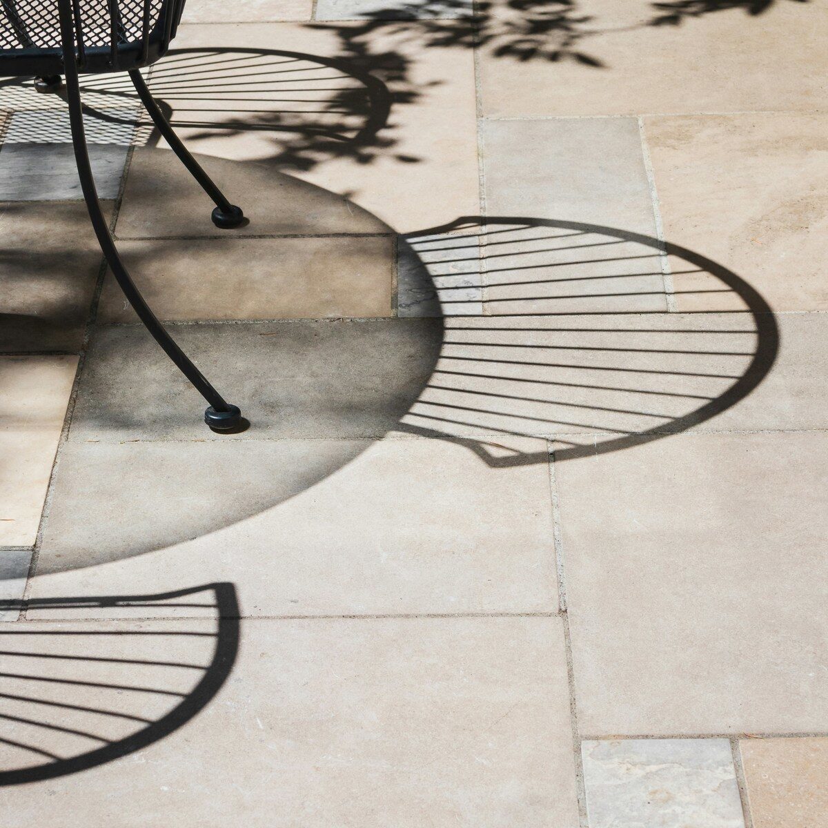 Black metal patio table base on stone tiles