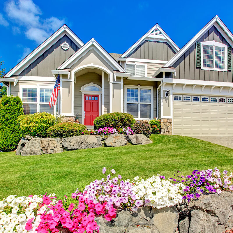 A house with a red door and a well-manicured lawn