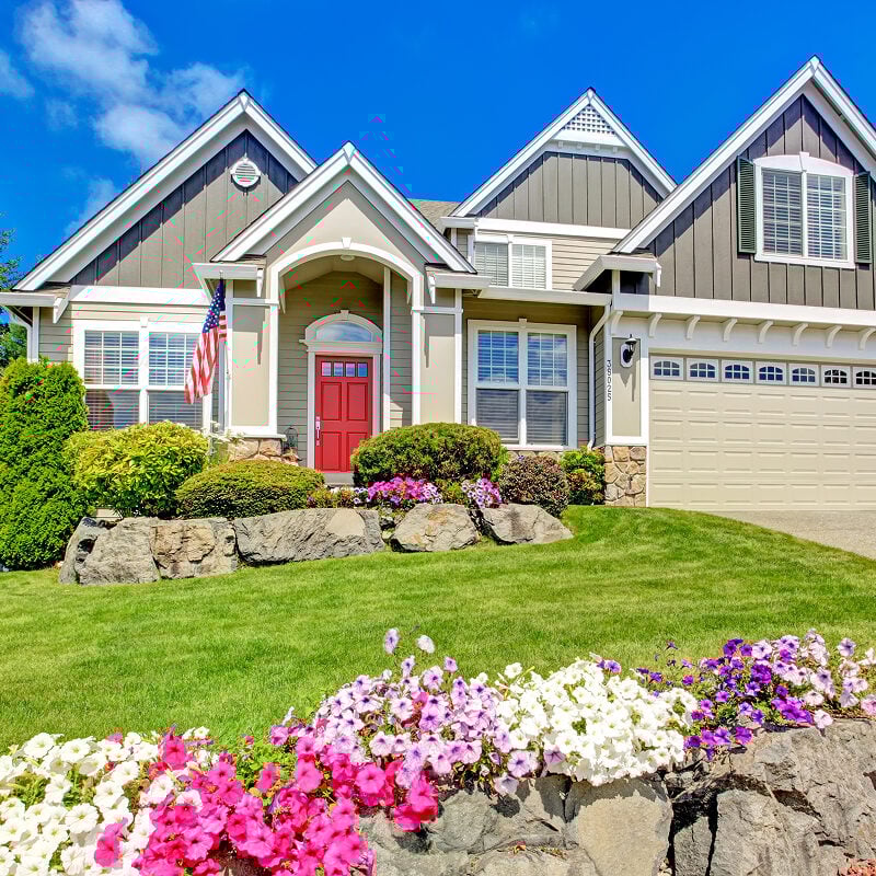 A house with a red door and a well-manicured lawn